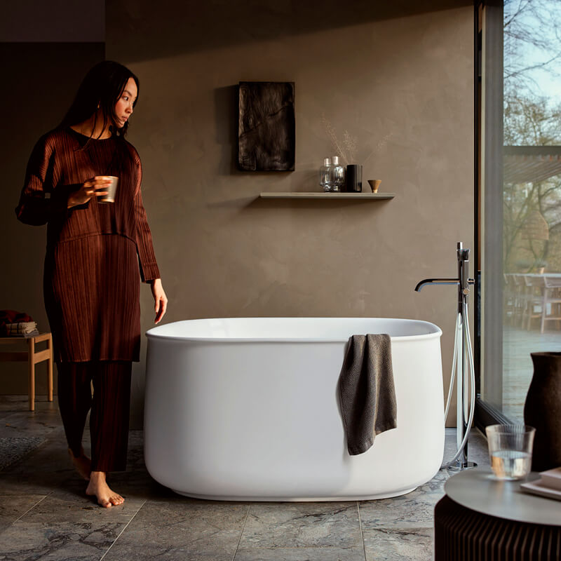 Woman in bathroom with freestanding Zencha bathtub
