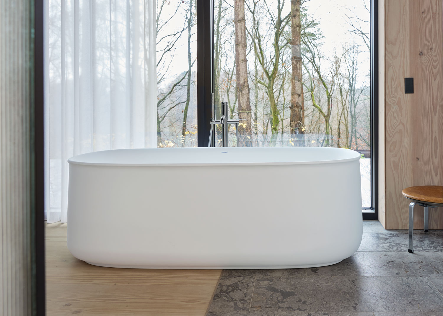 Free standing zencha bathtub in front of window
